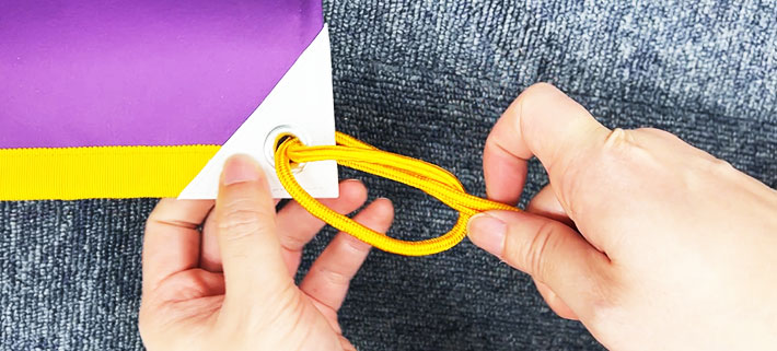 紐の折り目を広げた輪の中に、二本の紐の端を通しているイメージ画像