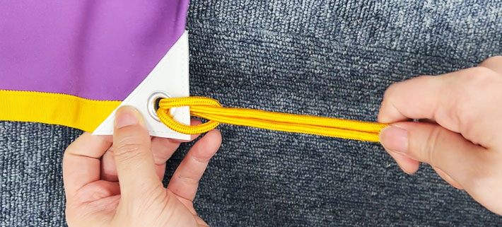 通した紐をしっかりと引っ張っている画像