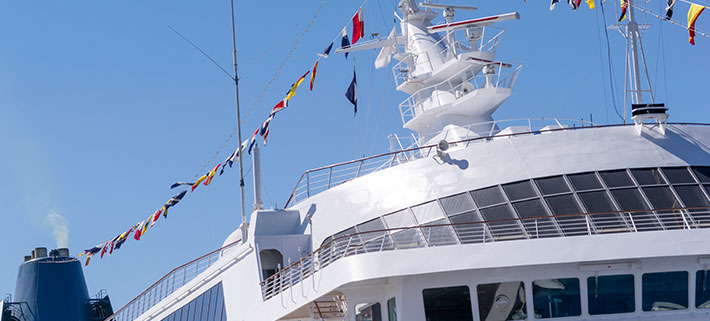 白色の船の上部に多数の国際信号旗が掲げられているイメージ画像